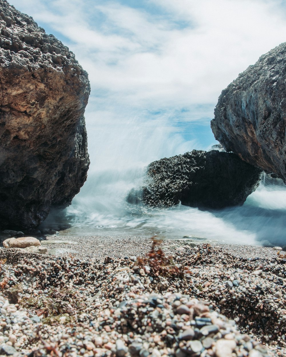 a rocky beach with waves crashing against the shore