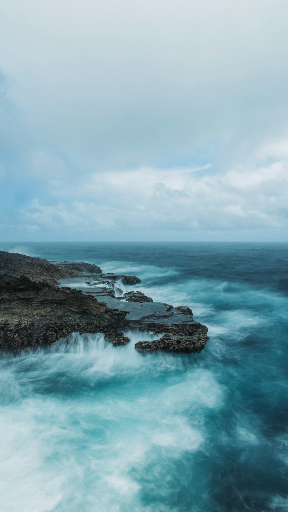 Une plage rocheuse avec de l’eau bleue