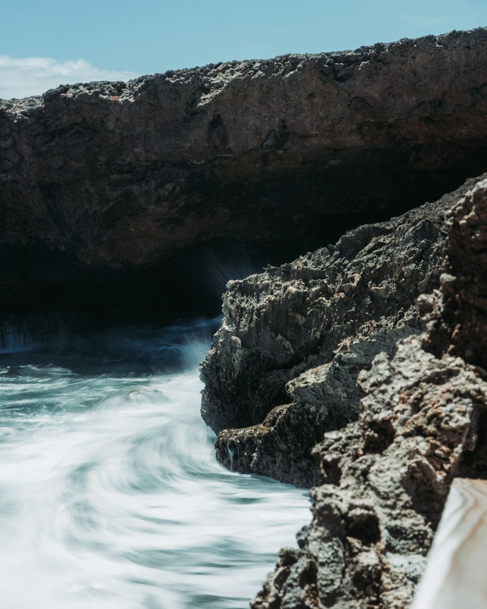 a rocky cliff next to a body of water