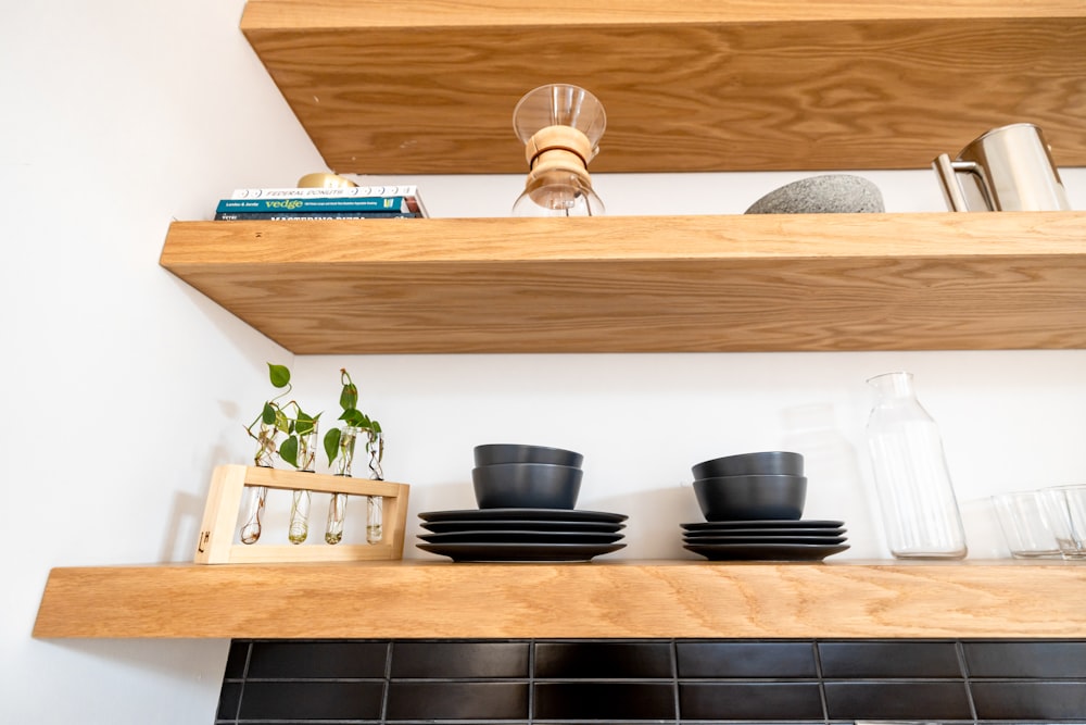 a shelf with bowls and plants on it