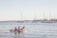 A happy family boarding a comfortable inflatable boat on a sunny Sardinian beach.