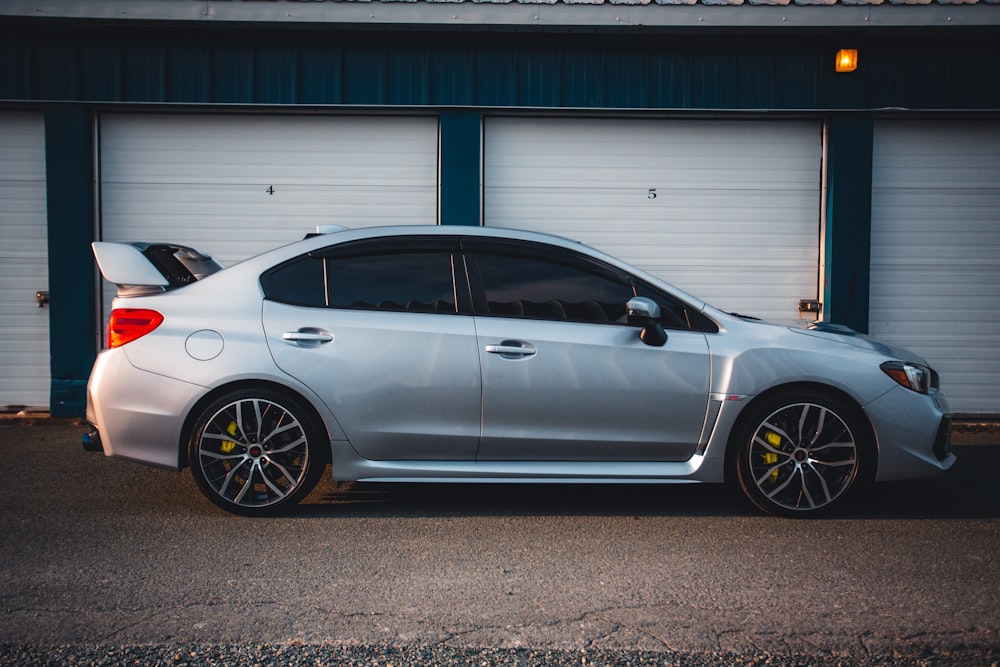 a silver car parked in front of a garage