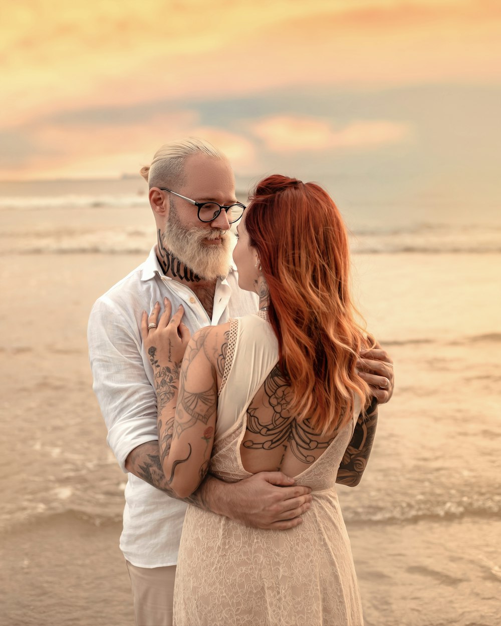 a man and woman hugging on a beach