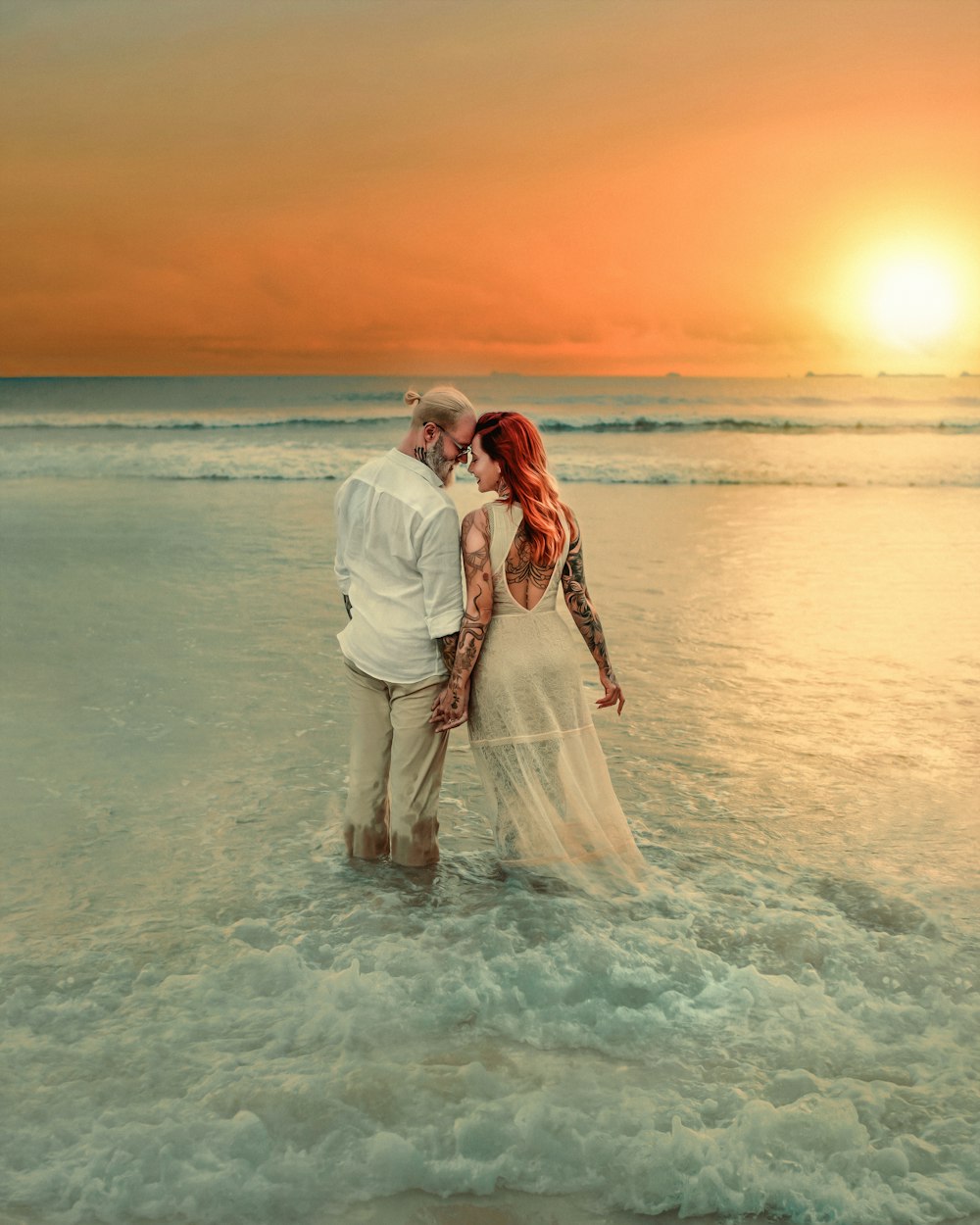 a man and woman kissing on a beach