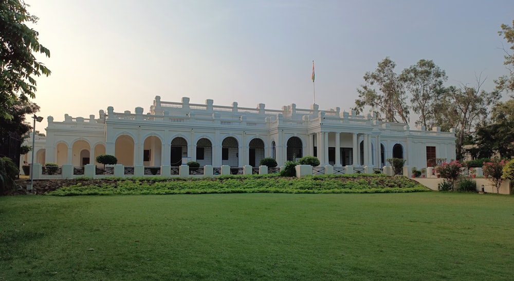 a large white building with a lawn in front of it