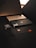 A dark-themed composition feature a smartphone, smartwatch, and a credit card. Each item displays a sleek, modern design, with the phone and smartwatch exhibiting metallic accents, while the credit card has a black matte finish with a prominent MasterCard logo.