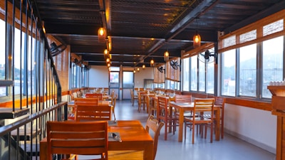 Cozy dining area with wooden tables and warm lighting inside the mie ayam dan bakso shop.