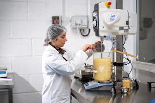 Laboratory technician working with chemical formulations and testing equipment.