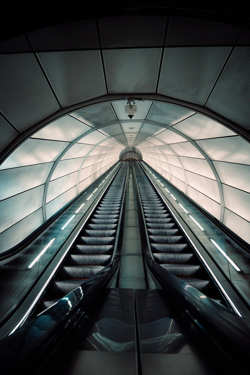a large escalator with a glass ceiling