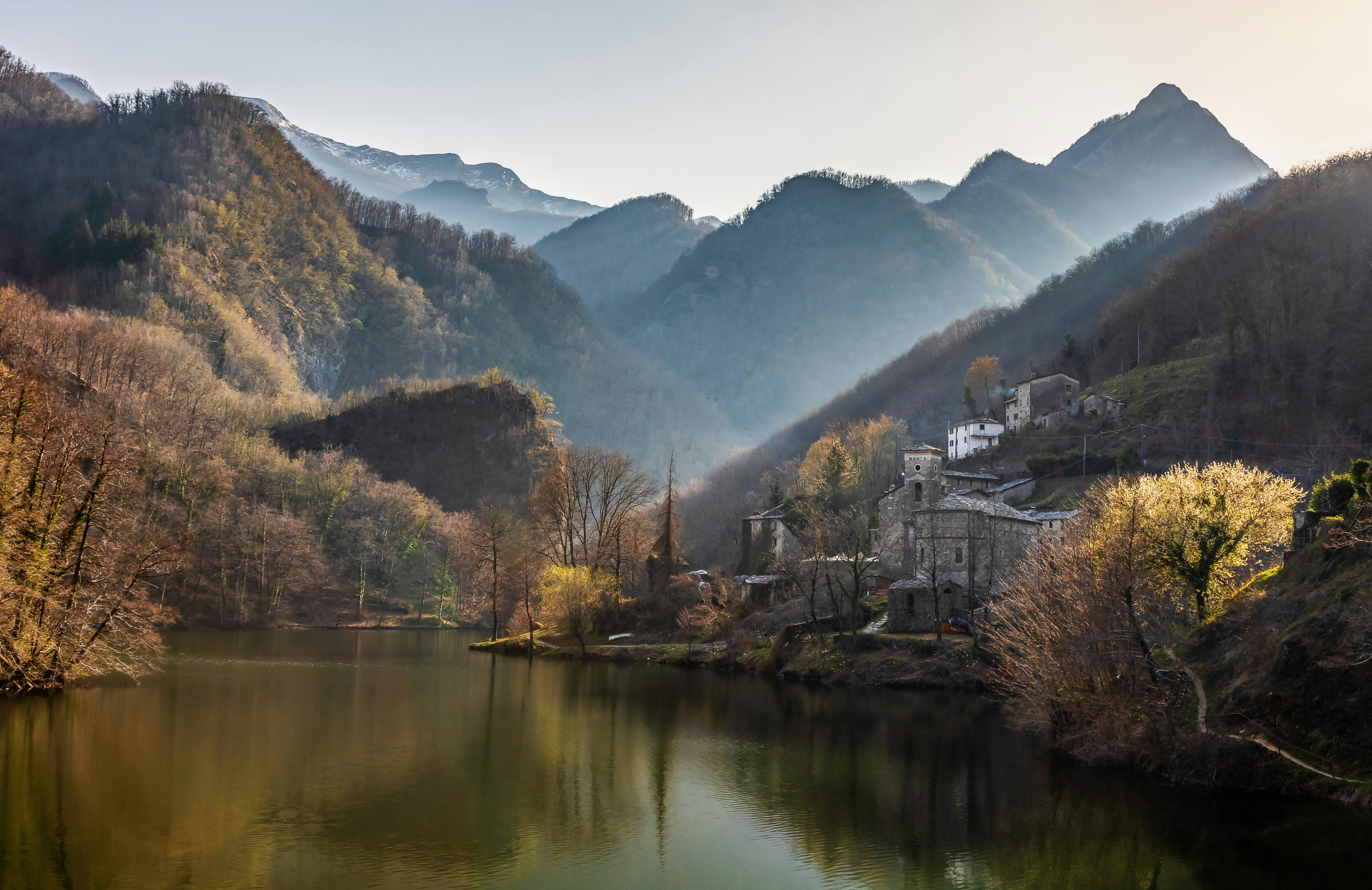 A lake with trees and mountains in the background
