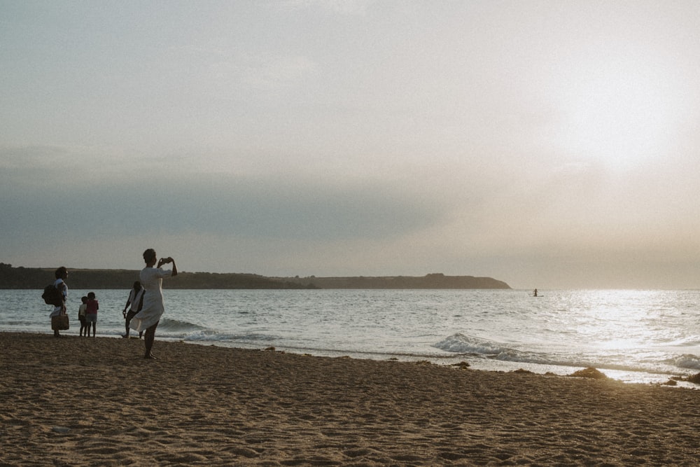 a couple of people on a beach near a body of water