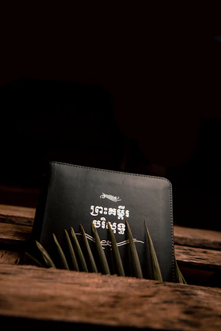 A mysterious ancient book glowing with arcane symbols on a dark wooden table.