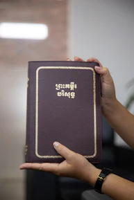 Close-up of hands holding a VA appointment prep guide with a gold and navy blue cover.
