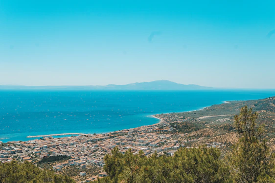 A vibrant coastal view of Freetown with its hills, beaches, and bustling port under a bright sky.
