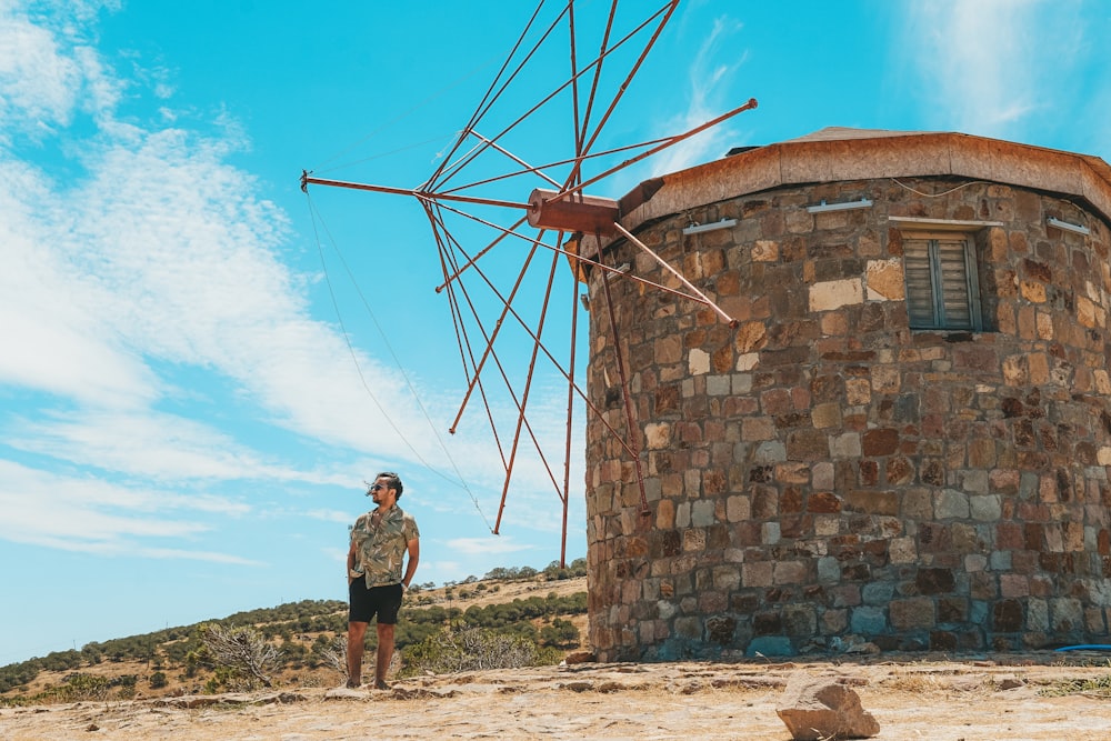 a man standing next to a stone building