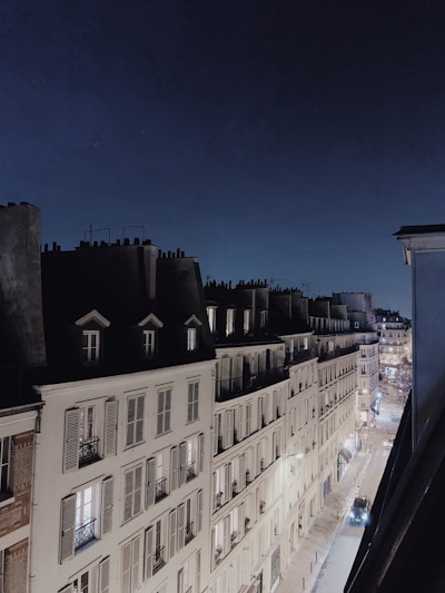 A sleek modern rolling shutter installed on a Parisian apartment window during sunset.