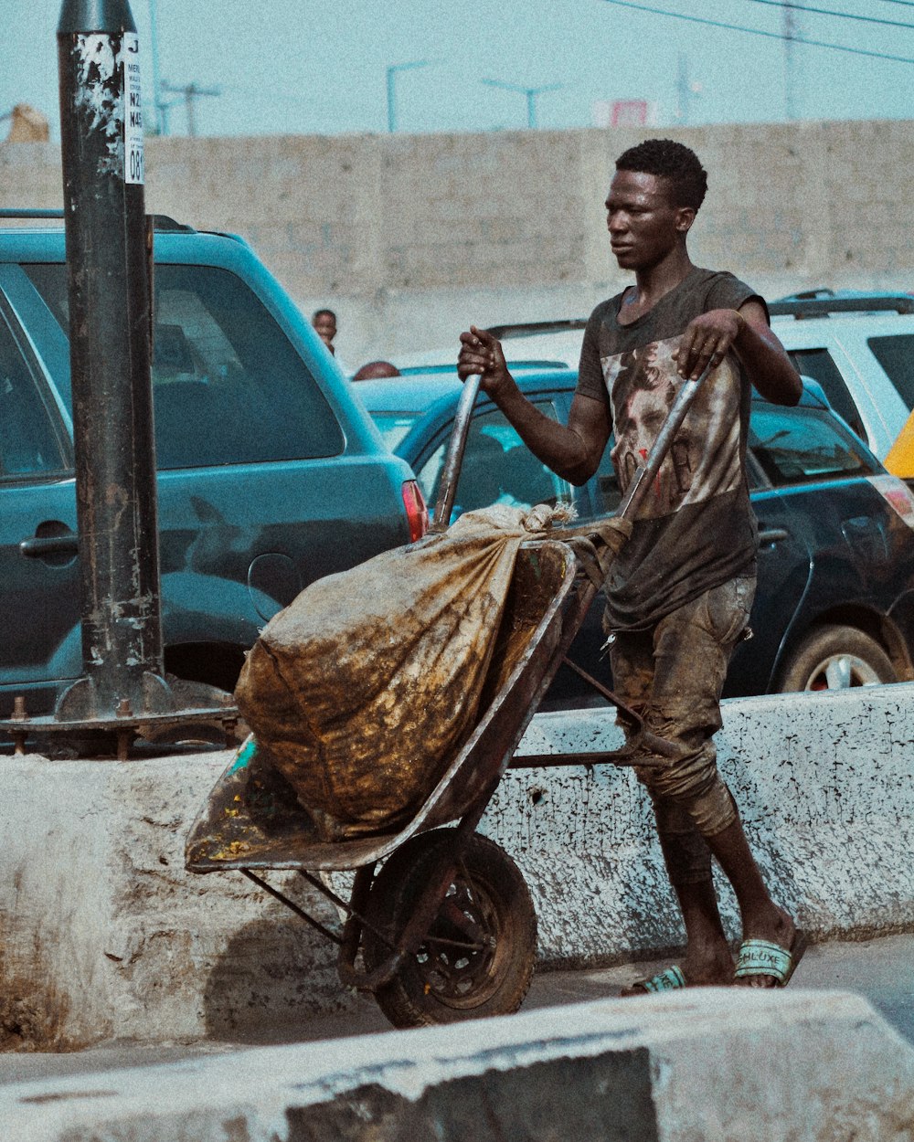 a man pushing a cart with a blanket on it