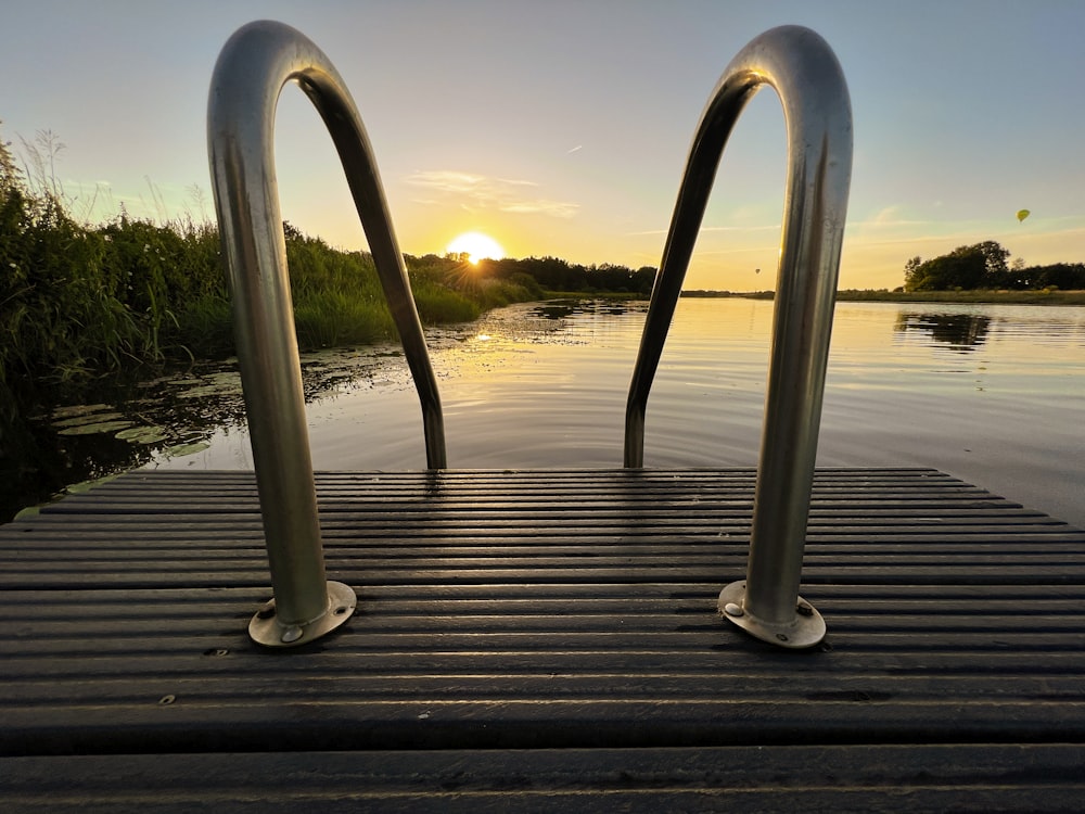 a group of metal objects on a wood surface with water in the background
