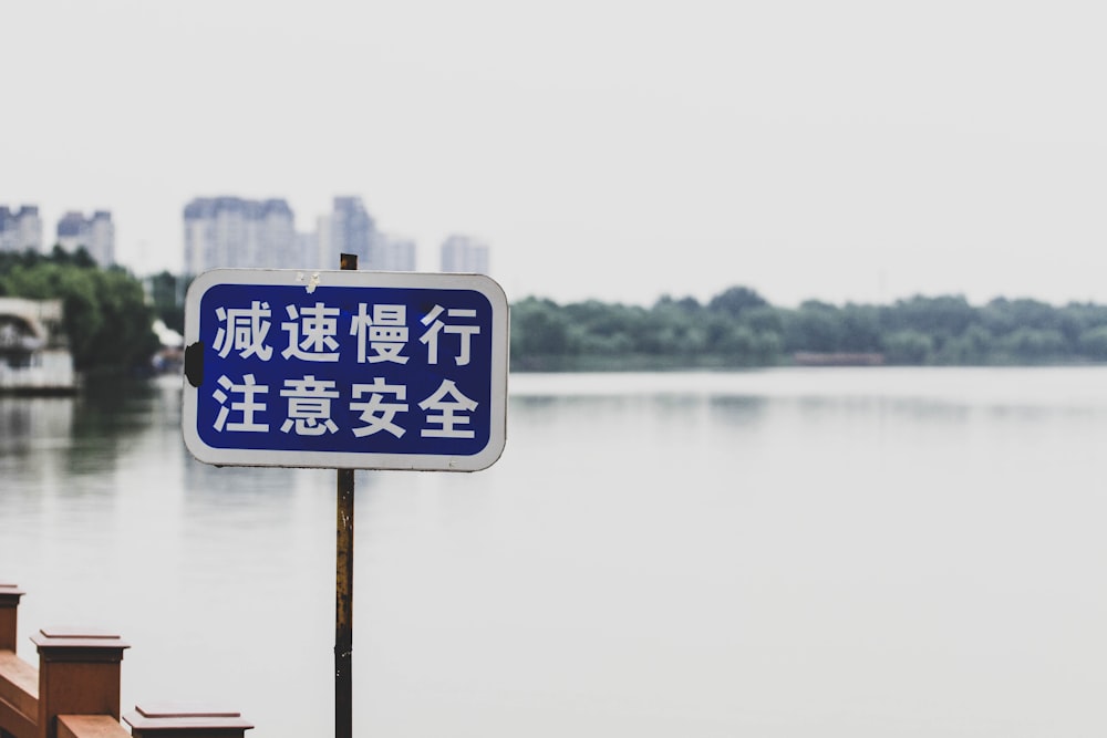 a sign in front of a body of water