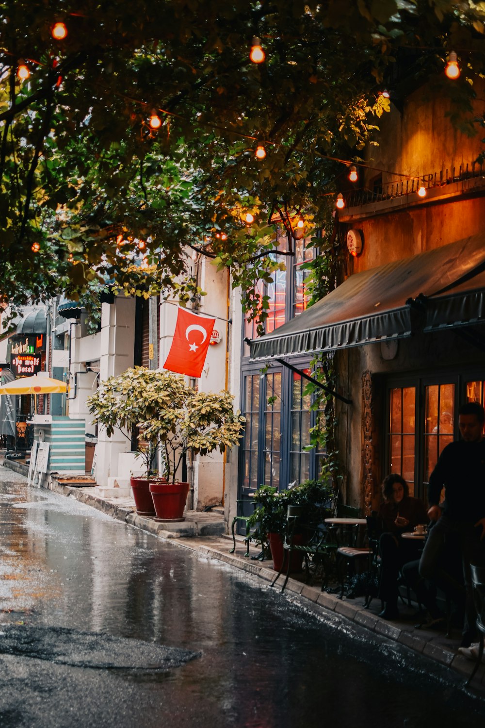 a street with tables and chairs and trees on the side