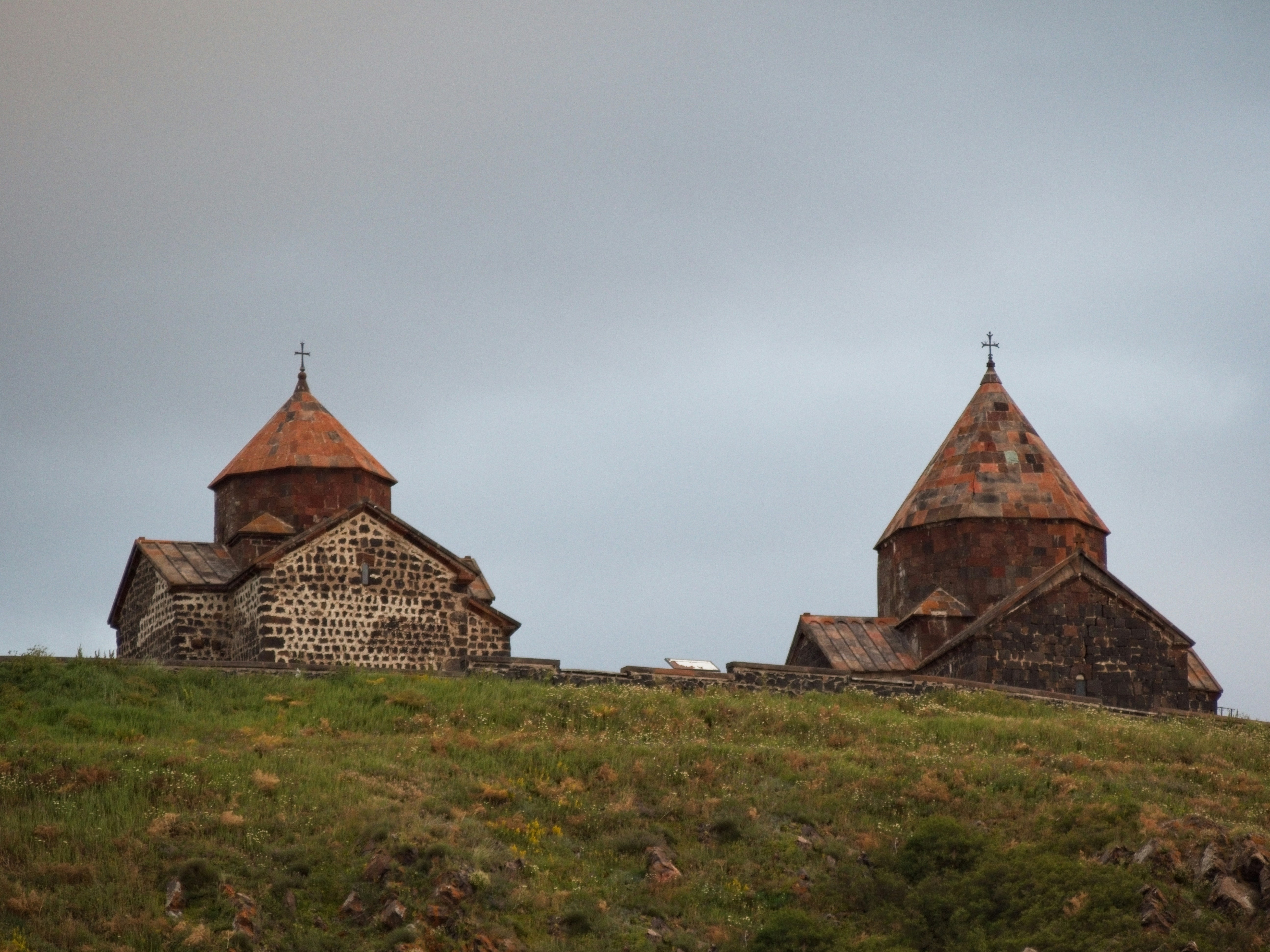 a couple of stone buildings on a hill