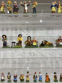 An elegant display of Chinese-style porcelain figurines arranged on a rustic shelf.