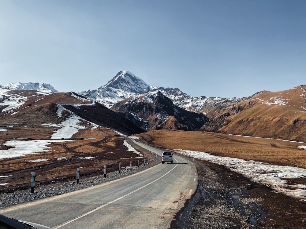 a car driving on a road in the mountains