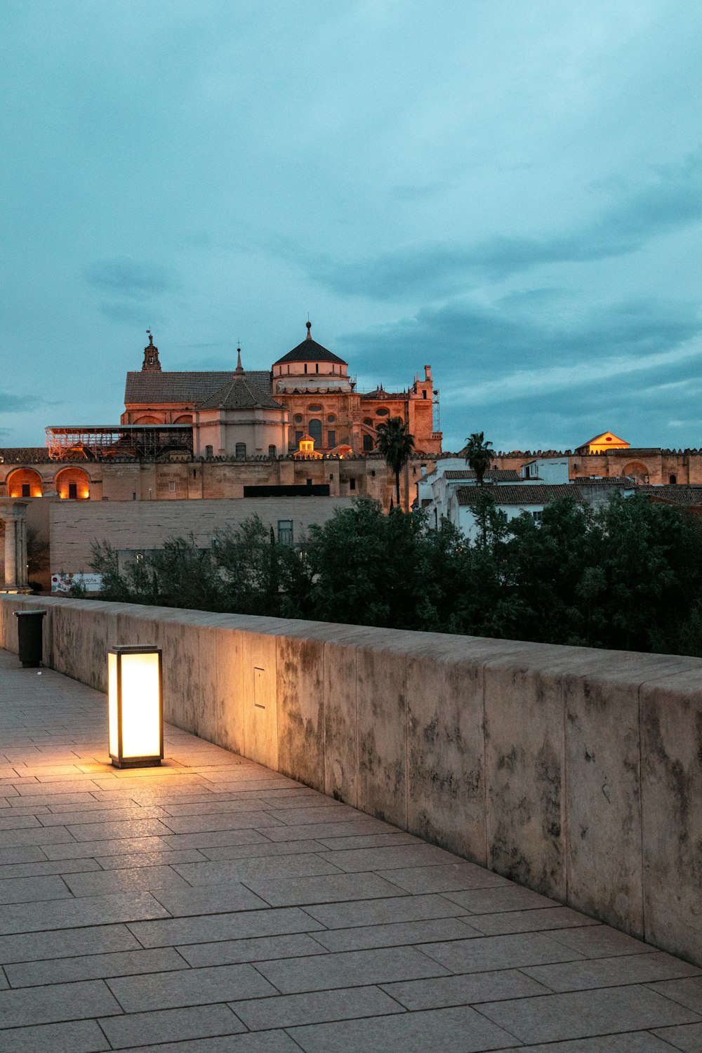 a stone walkway leading to a large building with a large tower