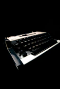 Close-up of a vintage typewriter with a black background and glowing keys