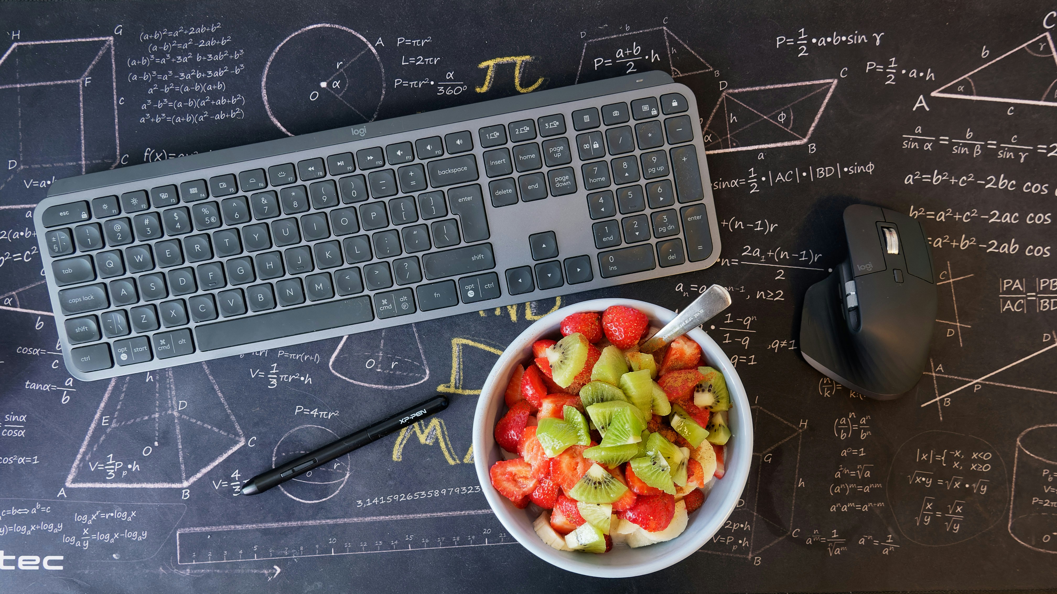 Fresh healty food with keyboard, mouse and pen on black mouse pad with math.