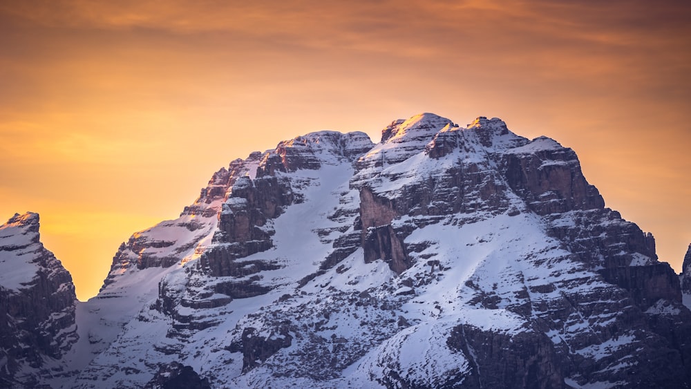 Ein verschneiter Berg mit Sonnenuntergang