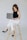 a woman sitting on a stool with a laptop