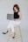 a woman sitting on a stool with a laptop
