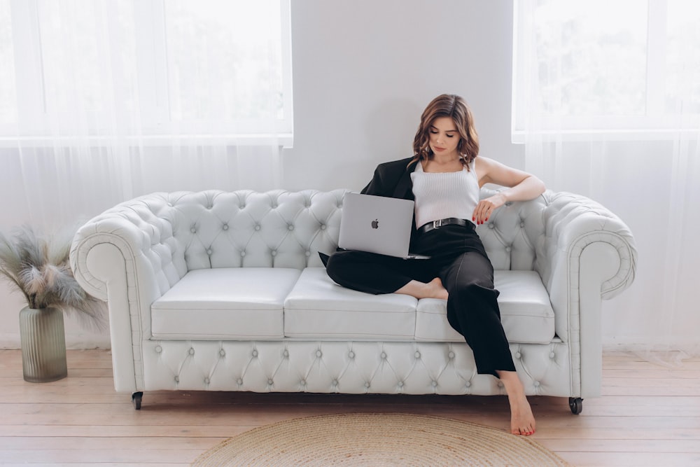 a woman sitting on a couch with a laptop