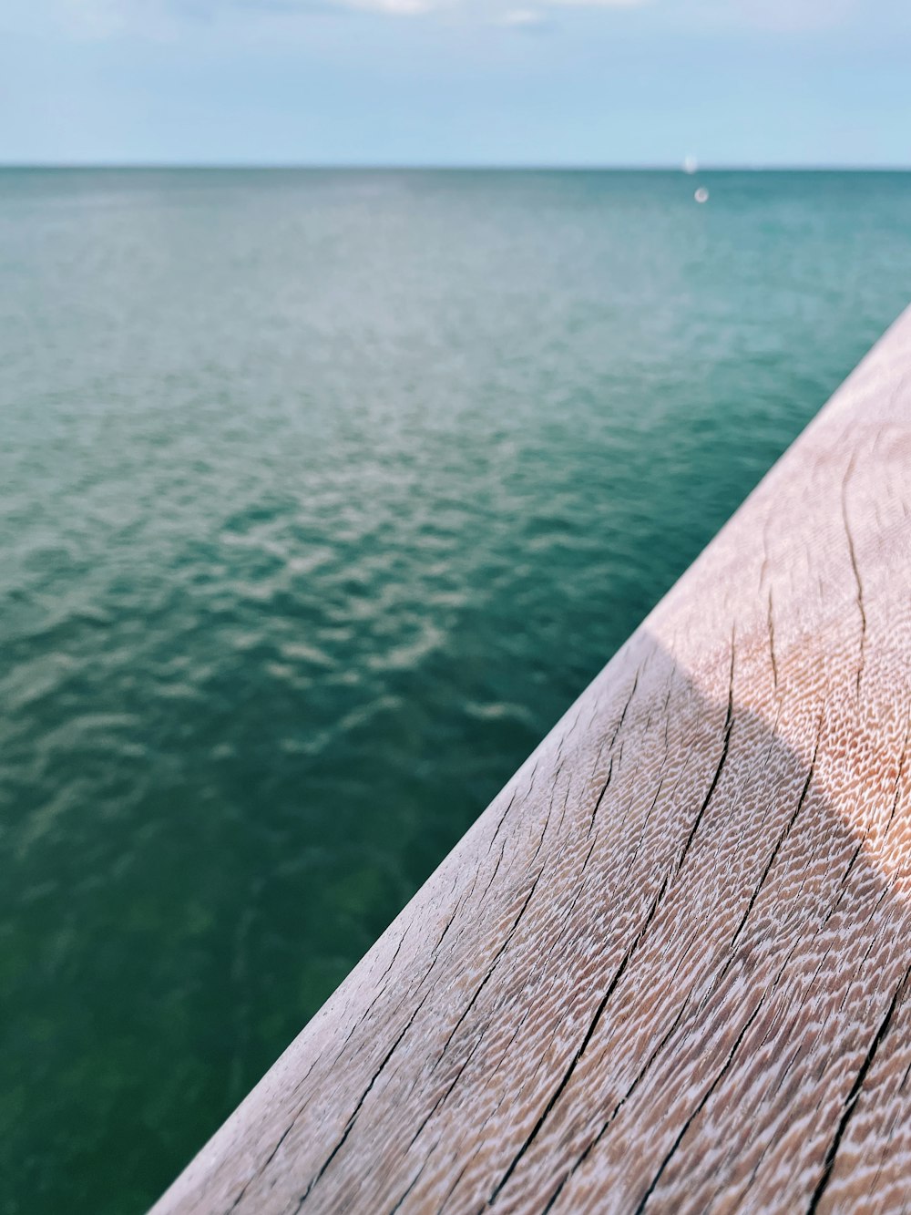 um corrimão de madeira com vista para o oceano