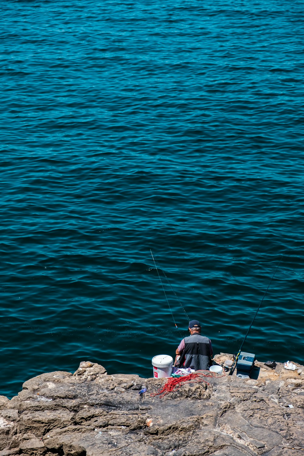 a man fishing on a rocky shore