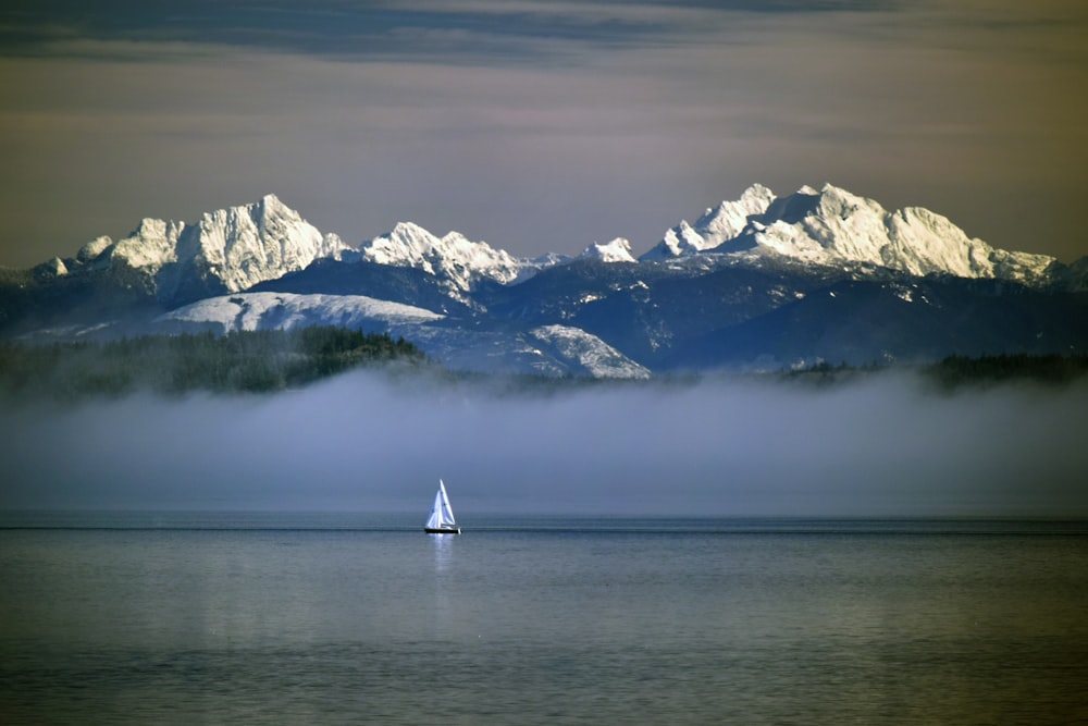 a boat in the water with mountains in the background