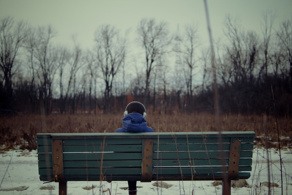 a person sitting on a bench in a snowy field