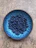 A vibrant blue ceramic plate filled with fresh fruit on a wooden table bathed in natural light.