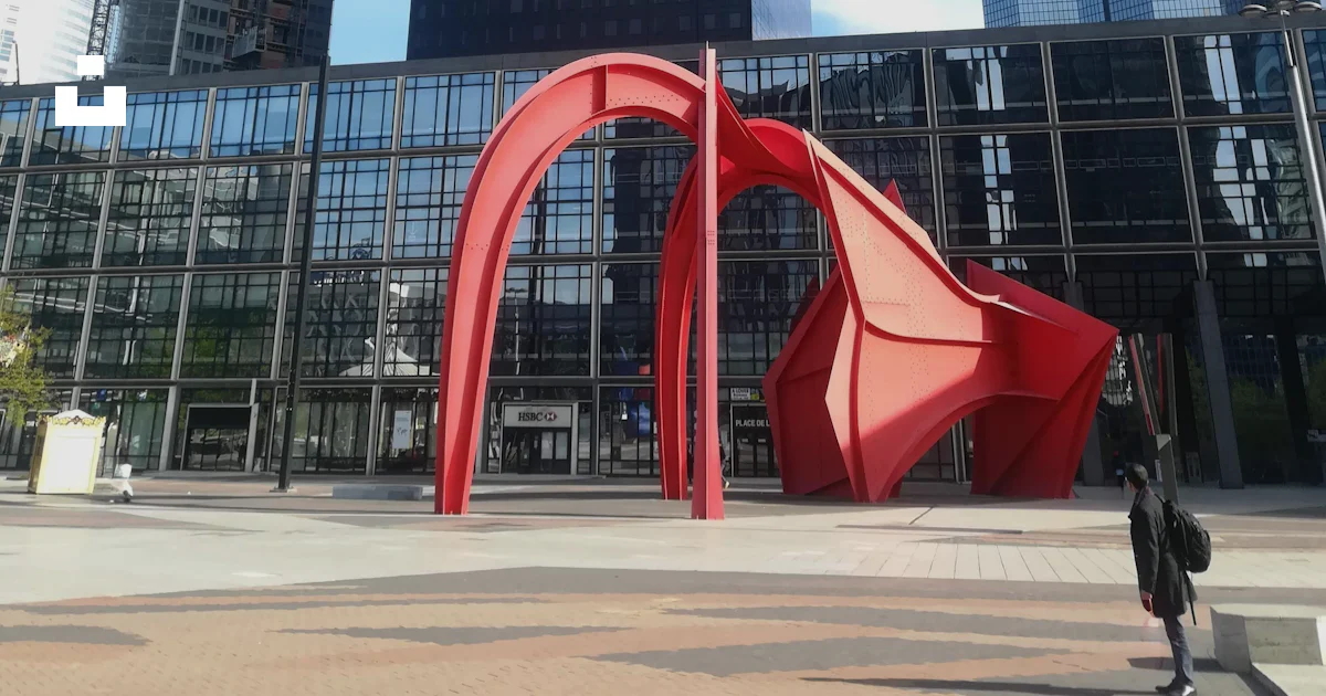 A large red structure in front of a group of tall buildings photo ...