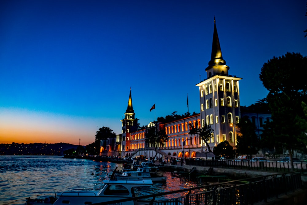 a building with a tower and boats in front of it