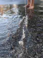 Close-up of feet in motion on a textured wooden floor with subtle splash patterns.