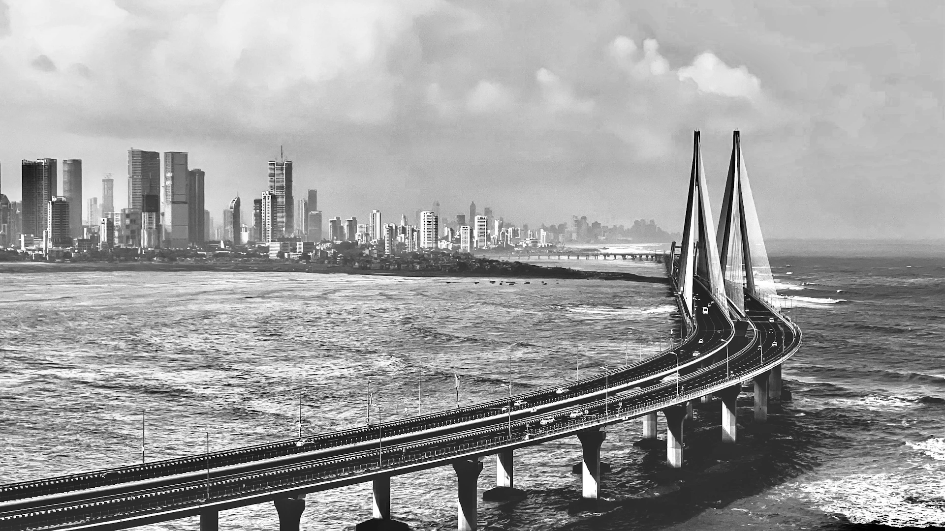 a bridge over water with a city in the background