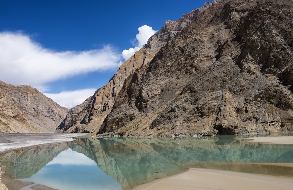 a body of water with a rocky cliff in the background