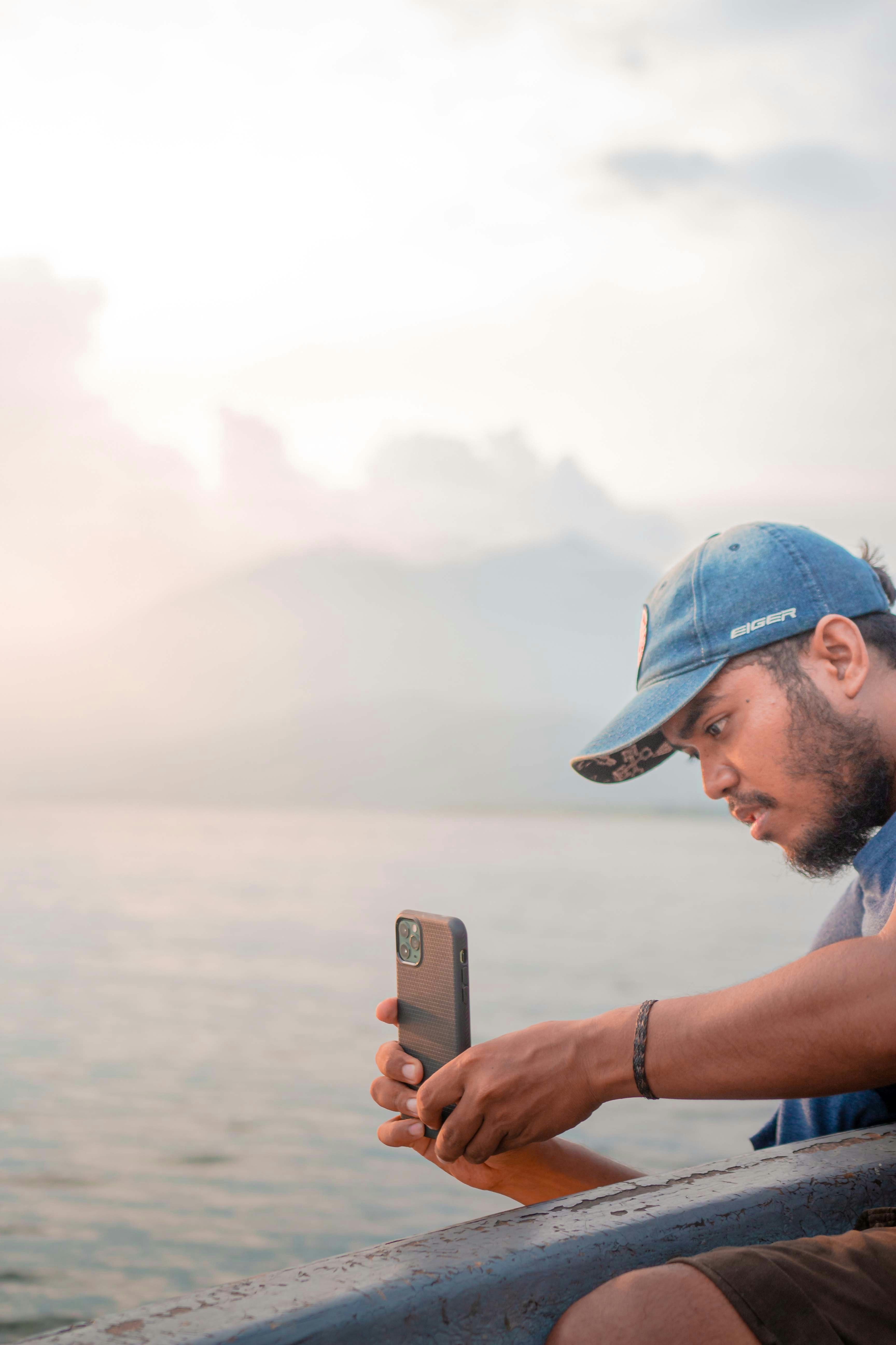 a man sitting on a boat looking at his phone