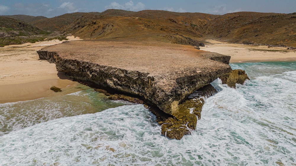 a large rock formation in the middle of a body of water