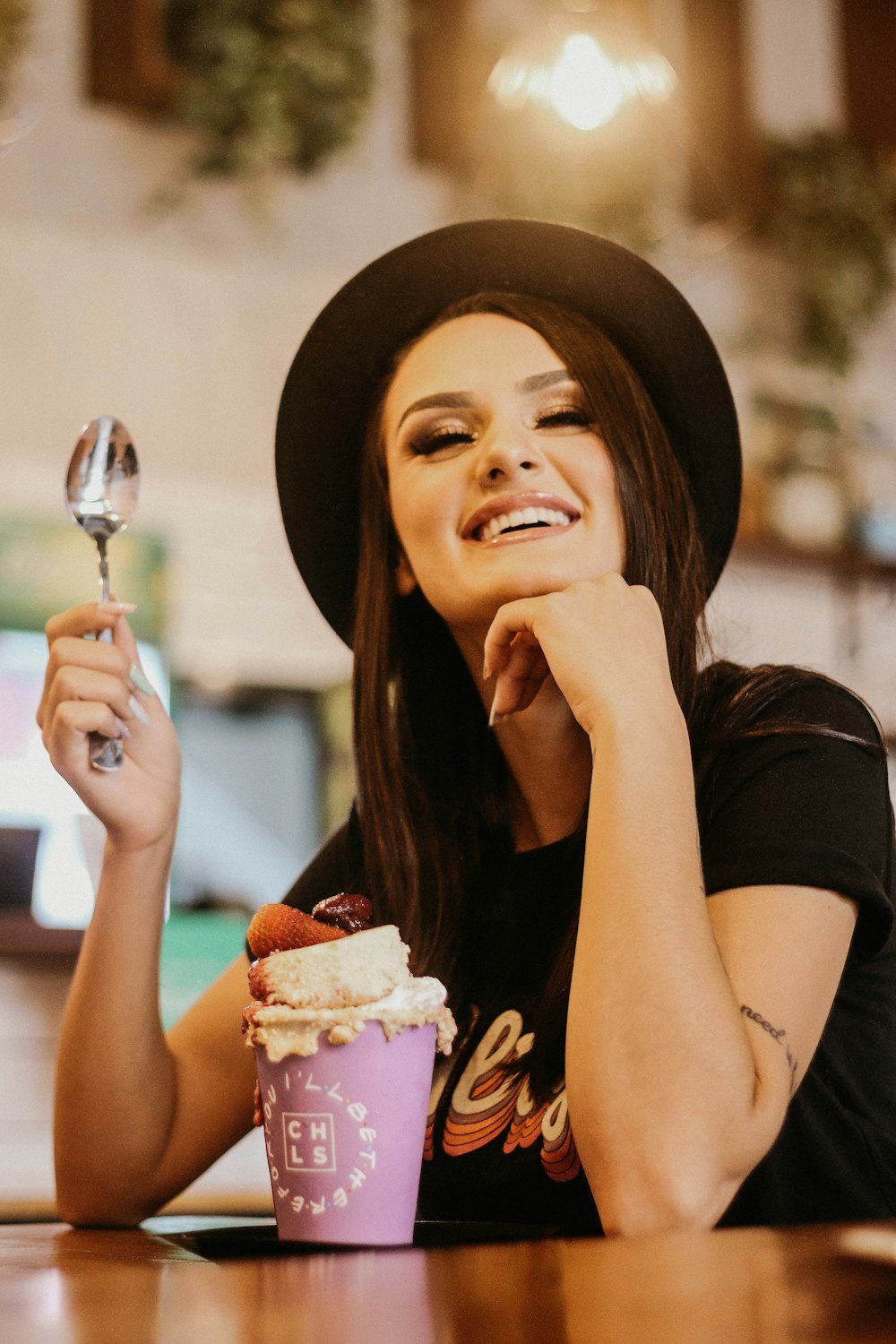 a woman holding a spoon and a cupcake