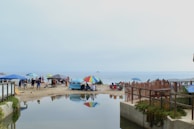 A lively beach scene with colorful umbrellas and happy families enjoying the sun.