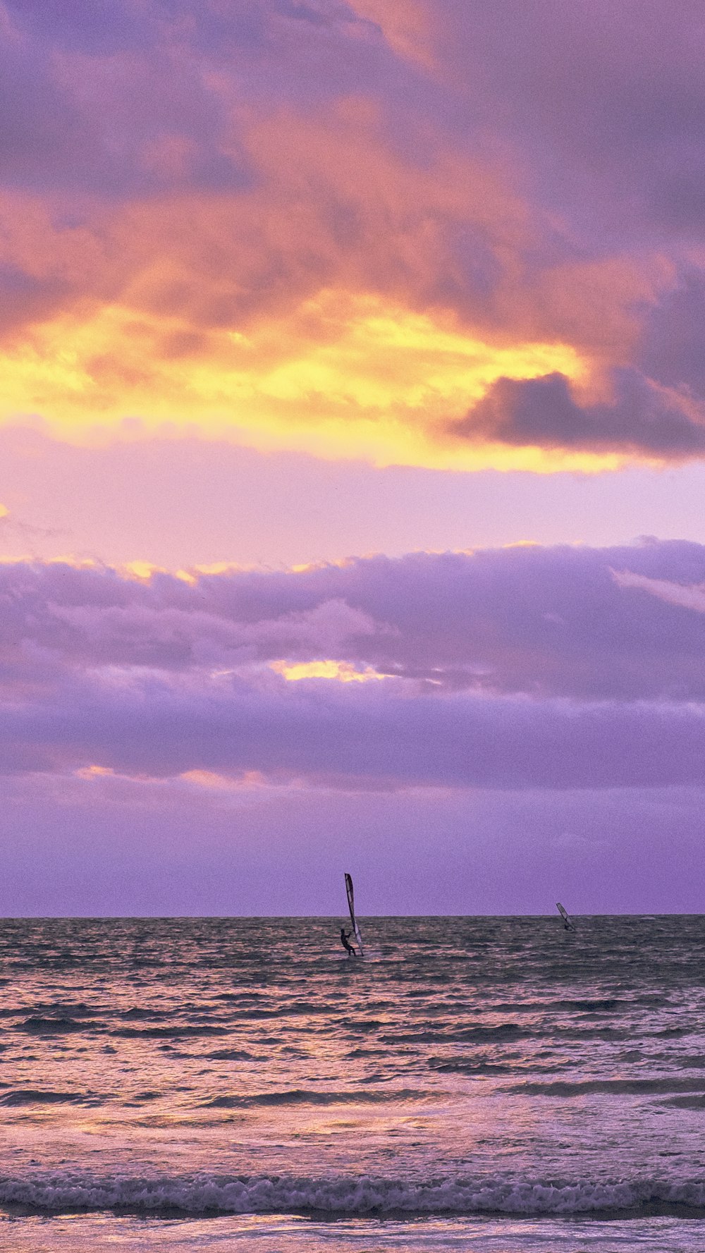 a body of water with a boat in it and a cloudy sky above