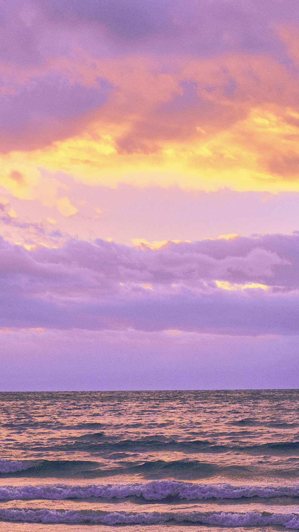 a body of water with a cloudy sky above it